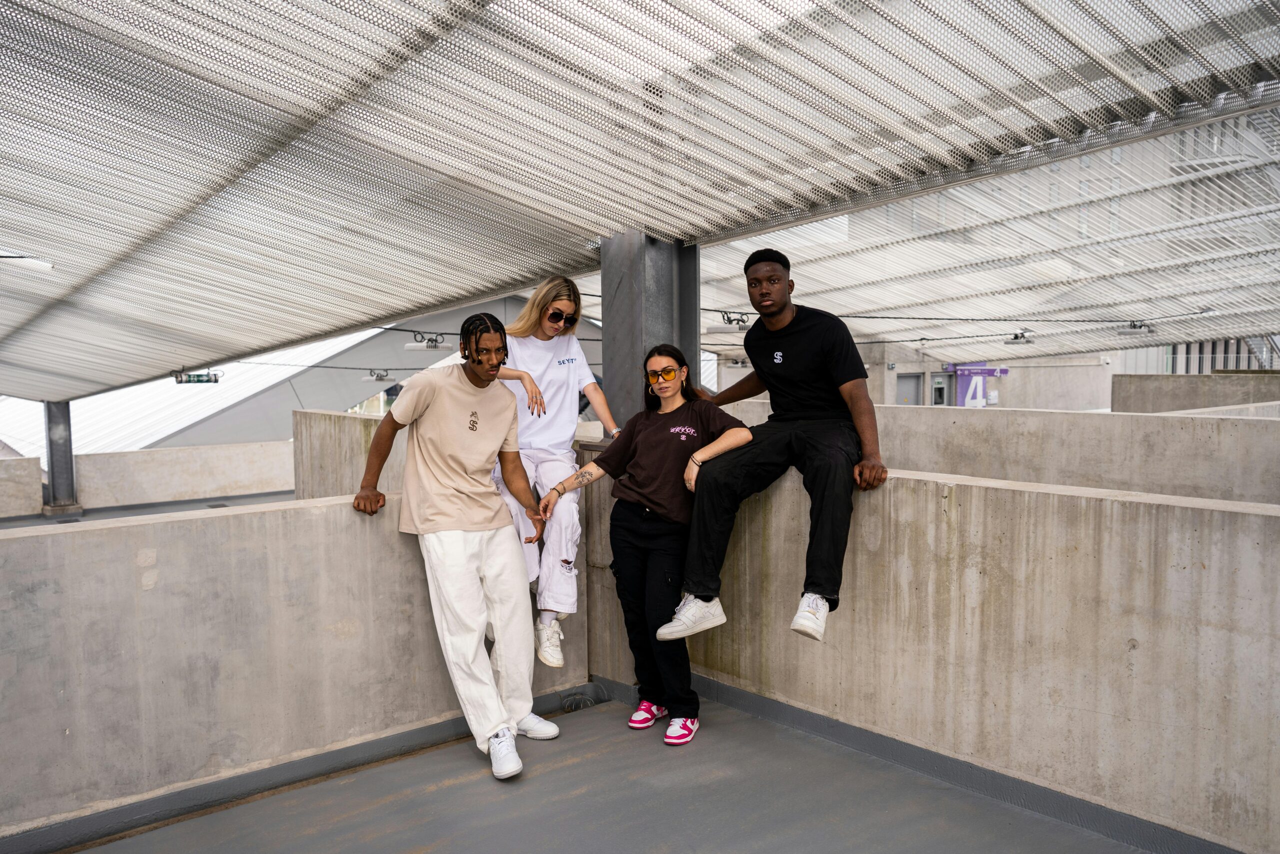 A group of stylish young friends posing together in a modern urban environment.